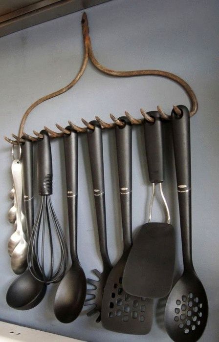 old rake in the role of railing for kitchen utensils