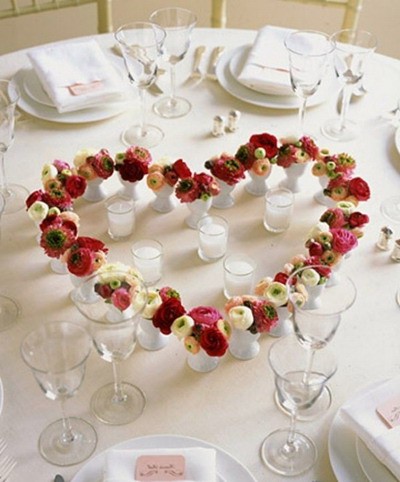 Corazón de flores en jarrones sobre la mesa 14 de febrero