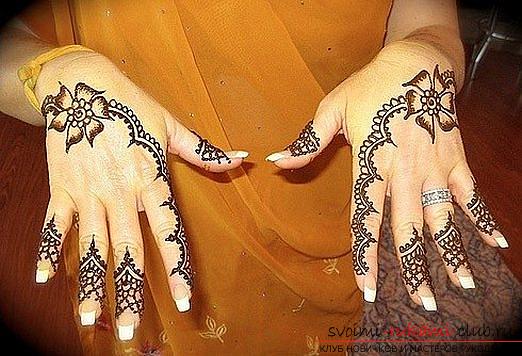 Maakt mehendi of schildert op het lichaam met de hulp van henna-handen. Foto №1