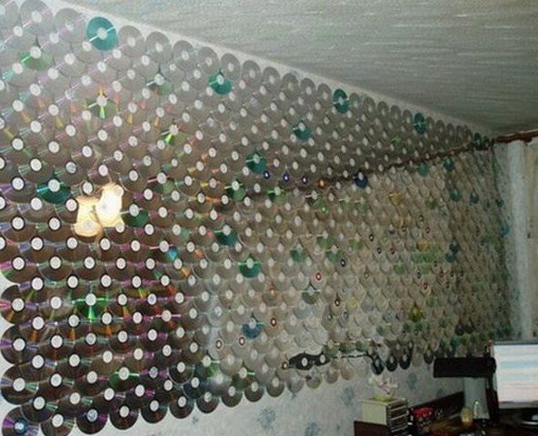 Een ongebruikelijke manier om een ​​muur te decoreren en de ruimte visueel uit te breiden via cd's