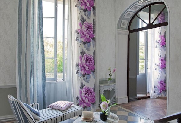 Curtains with purple flowers in a bright room.