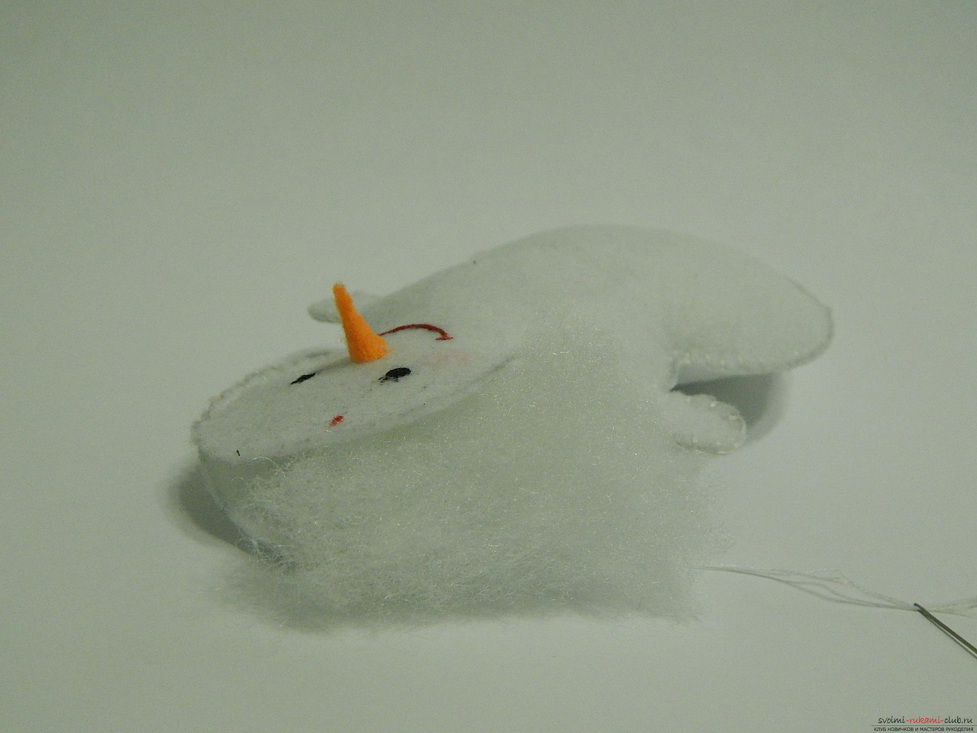 A master class with step-by-step photos will teach you how to make a snowman from felt. Photo number 20
