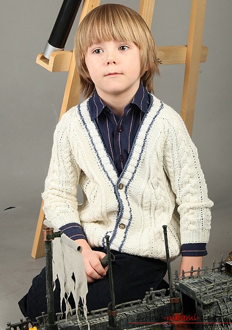 Met een jas voor een jongen breien. breipatroon van een gebreid vest met gedetailleerde beschrijving. Foto's en aanbevelingen over de selectie van garen voor het breien van een jas. Foto №1
