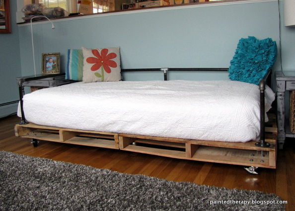 Bed with own hands made of wooden pallets and metal pipes