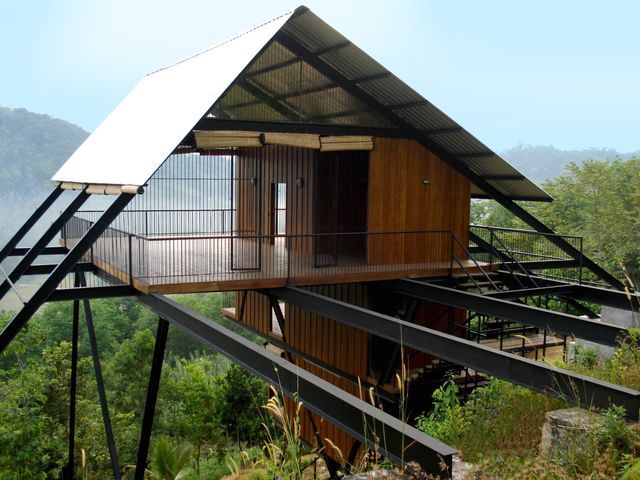 wooden house on stilts over trees in the jungle 