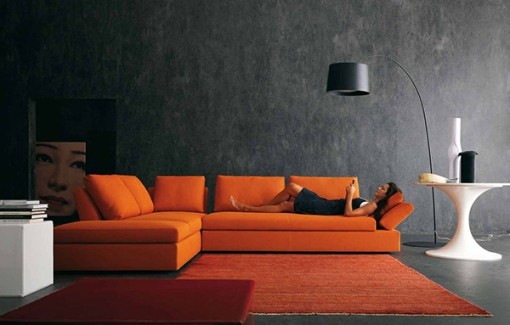 Bright orange sofa and dark walls