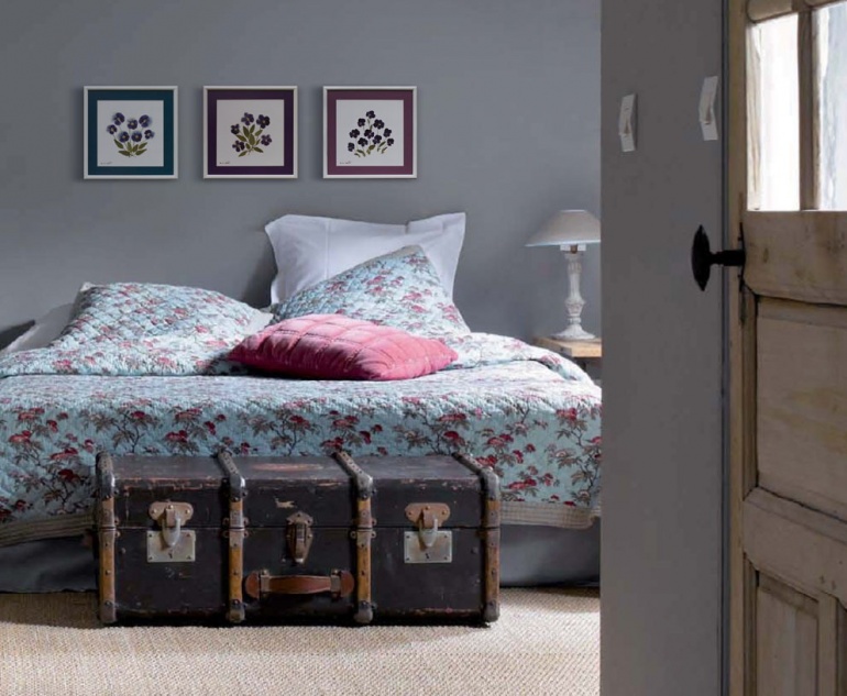 An old suitcase and herbariums in the bedroom interior remind of a pleasant journey