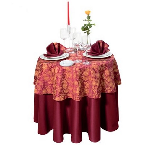 A beautiful combination of two different color and texture tablecloths on a round table