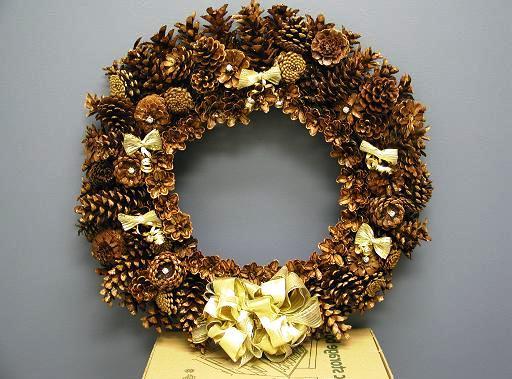 Christmas wreath of cones with his hands on the door